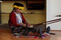 Peruvian indigenous woman is weaving a carpet.