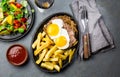 Peruvian Latin American food. Lomo a lo pobre. Beef whit fried potatoes french fry and eggs. served with salad. Top view Royalty Free Stock Photo