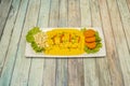 Peruvian recipe of fish tiradito with cooked corn, lots of yellow sauce and slices