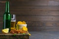 Peruvian squid with beer, lemon and potato chips on dark wooden board. Snack on fish with beer. Front views with clear space Royalty Free Stock Photo