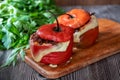 Peruvian traditional dish Rocoto relleno stuffed pepper with baked meat and melted cheese on a wooden board