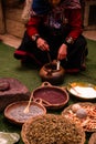 Peruvian woman hand-dyeing wool with other natural wool dyes on display - vertical shot