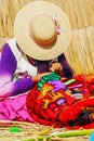 Peruvian women knitting traditional handmade craft in Uros Island, Puno, Peru