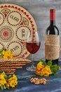 Pesach celebration concept - Jewish holiday Pesach. Background with yellow flowers with glass of wine, matzah and plate Royalty Free Stock Photo