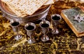 Pesach Passover symbols of great Jewish holiday. Traditional matzoh, matzah or matzo and wine in vintage silver glass