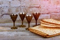 Pesach Passover symbols of great Jewish holiday. Traditional matzoh, matzah or matzo and wine in vintage silver plate and glass.