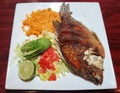 Pescado Frito, a fried tilapia with yellow rice, salad and a side of salsa and avocado slices Royalty Free Stock Photo