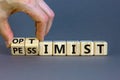 Pessimist or optimist symbol. Businessman turns cubes and changes the word `pessimist` to `optimist`. Beautiful grey table, gr Royalty Free Stock Photo