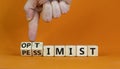 Pessimist or optimist symbol. Businessman turns cubes and changes the word `pessimist` to `optimist`. Beautiful orange table, Royalty Free Stock Photo