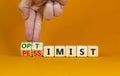 Pessimist or optimist symbol. Businessman turns cubes and changes the word `pessimist` to `optimist`. Beautiful orange table, Royalty Free Stock Photo