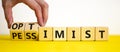 Pessimist or optimist symbol. Businessman turns cubes and changes the word `pessimist` to `optimist`. Beautiful yellow table,