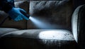 Pest control worker examines a home sofa for cockroaches and other pests using a flashlight. This inspection aims for Royalty Free Stock Photo