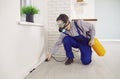 Pest control worker in a mask and overall workwear spraying poison inside the house Royalty Free Stock Photo