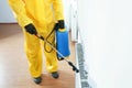 Pest control worker in protective suit spraying pesticide, closeup. Space for text Royalty Free Stock Photo