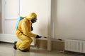 Pest control worker in protective suit spraying pesticide. Space for text Royalty Free Stock Photo