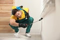 Pest control worker spraying insecticide on window sill Royalty Free Stock Photo