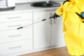 Pest control worker spraying pesticide in kitchen Royalty Free Stock Photo