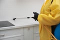 Pest control worker spraying pesticide on kitchen counter, closeup Royalty Free Stock Photo