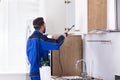 Pest Control Worker Spraying Pesticide In Kitchen Royalty Free Stock Photo