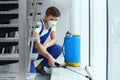 Pest control worker spraying pesticide near window Royalty Free Stock Photo