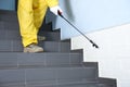 Pest control worker spraying pesticide on stairs indoors, closeup Royalty Free Stock Photo