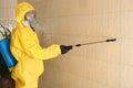 Pest control worker spraying pesticide on wall Royalty Free Stock Photo
