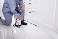 Pest Control Worker Spraying Pesticide On White Cabinet Royalty Free Stock Photo