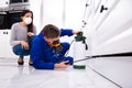 Pest Control Worker Spraying Pesticide On Wooden Cabinet Royalty Free Stock Photo