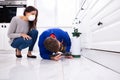 Pest Control Worker Spraying Pesticide On Wooden Cabinet Royalty Free Stock Photo