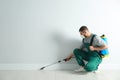 Pest control worker in uniform spraying pesticide. Space for text Royalty Free Stock Photo