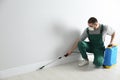 Pest control worker in uniform spraying pesticide. Space for text