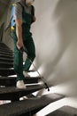 Pest control worker in uniform spraying pesticide on stairs indoors Royalty Free Stock Photo