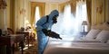 Pest controller works in a French hotel bedroom exterminating bedbugs Royalty Free Stock Photo