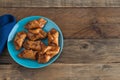 PestiÃÂ±os. Typical sweet of Christmas and Easter. Carnival fried sweets in blue plate on wooden background