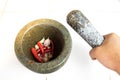 Pestle in woman hand above the mortar with chilli and garlic ins Royalty Free Stock Photo