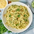 Pesto pasta, bavette with walnuts, parsley, garlic, nuts, olive oil. Top view, close-up, blue background.