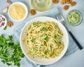 Pesto pasta, bavette with walnuts, parsley, garlic, nuts, olive oil. Top view, close-up, blue background