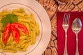 Pesto penne pasta with fresh tomatoes and iced tea on a tree stump background. Royalty Free Stock Photo