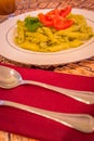 Pesto penne pasta with fresh tomatoes and iced tea on a tree stump background. Royalty Free Stock Photo