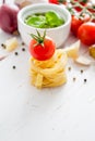 Pesto sauce pasta and tomatoes, white wood background Royalty Free Stock Photo