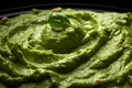 Pesto spread texture background. Green Italian homemade spilled sauce made of ground basil, garlic, pine seeds, olives and