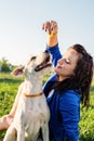 Young attractive woman feeding her dog in the park in summer day Royalty Free Stock Photo