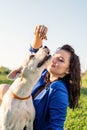 Young attractive woman feeding her dog in the park Royalty Free Stock Photo