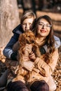 Pet care advice for autumn. Happy family mother and teen boy son walking and having fun with cocker spaniel puppy Royalty Free Stock Photo