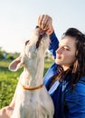 Young attractive woman feeding her dog in the park Royalty Free Stock Photo