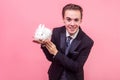 Pet care. Portrait of cheerful handsome man holding cute bunny rabbit on his palm. isolated on pink background Royalty Free Stock Photo