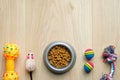 Pet care and training concept. Dry food in bowl and accessories for cat and dog on wooden table top view. Pet shop banner mockup