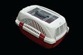 Pet carrier red and white for traveling with a pet on isolated black Royalty Free Stock Photo