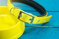 Pet collars and Bowls of yellow on wooden background.