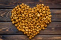 Pet dry food in shape of heart on wooden background top view Royalty Free Stock Photo